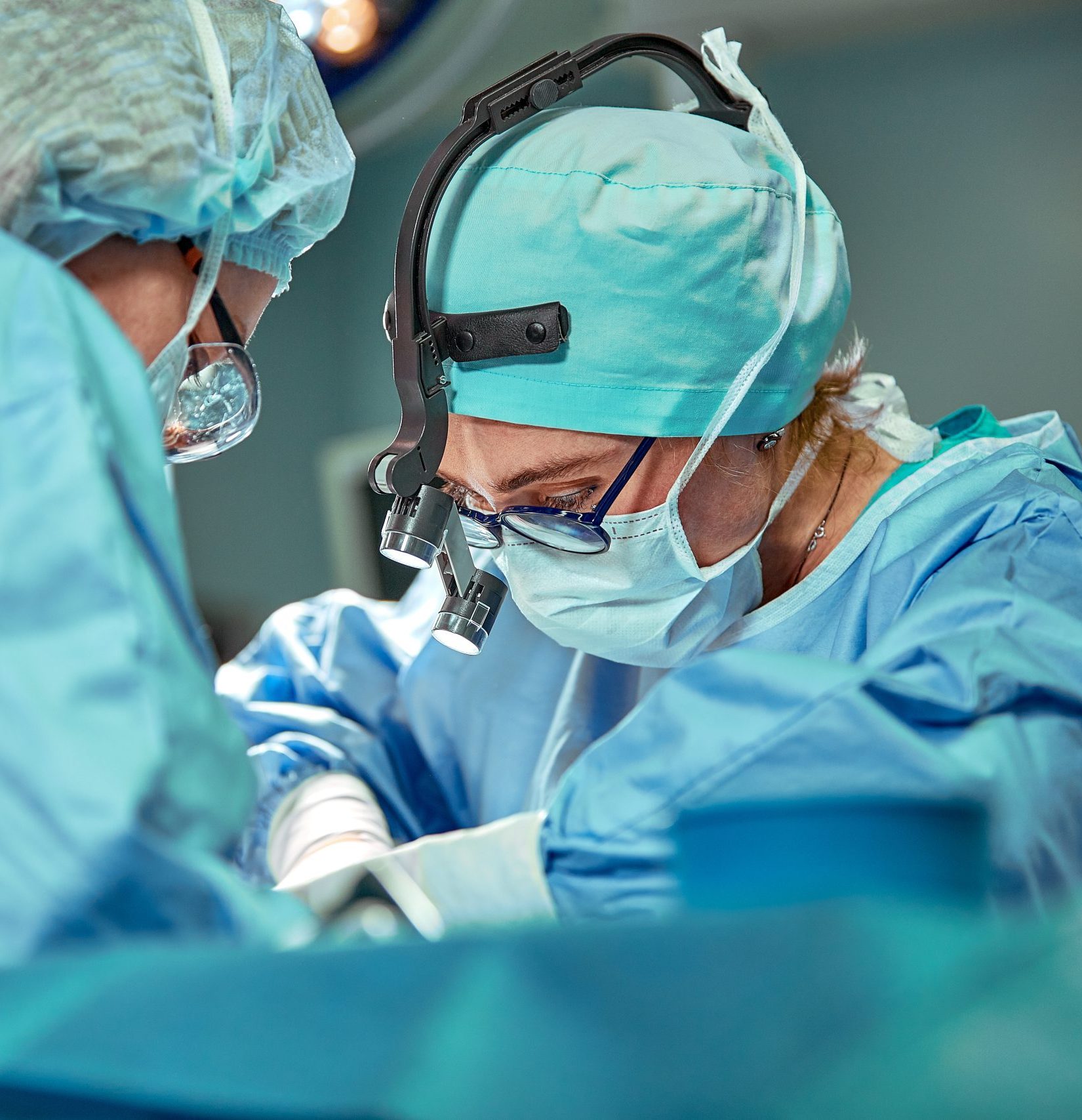 Group of surgeons looking at patient on operation table during their work